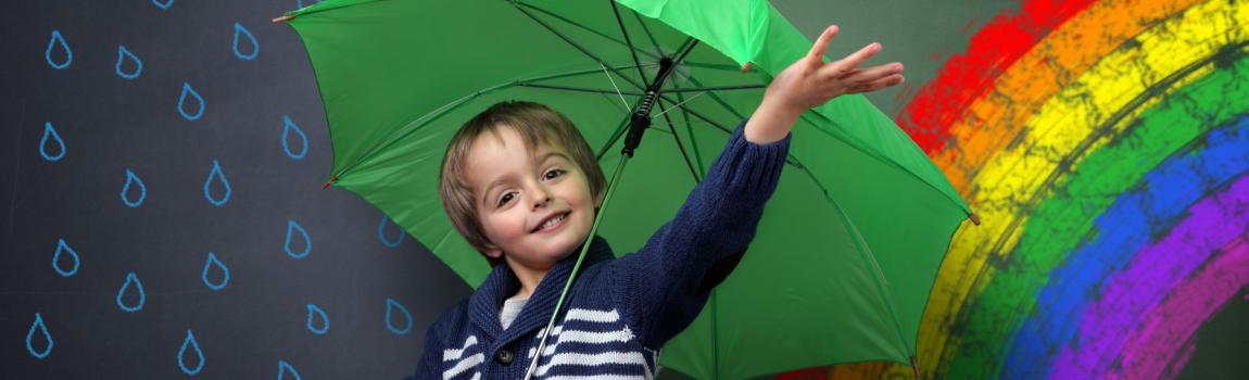 Deutsche Stiftung Verbraucherschutz/BrianAJackson - stock.adobe.com Junge vor bemalter Tafel mit Sonne, Wolken, Regenbogen