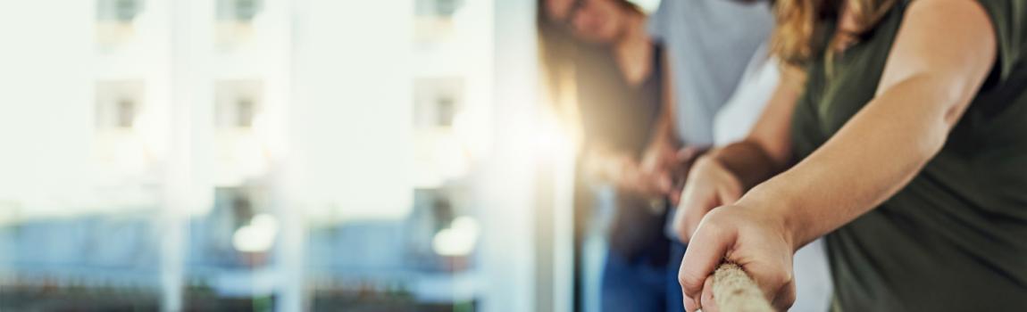 iStock.com/Layla Bird Frauen ziehen am Tau