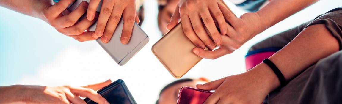 iStock.com/ Kerkez Kinder halten Smartphones im Kreis