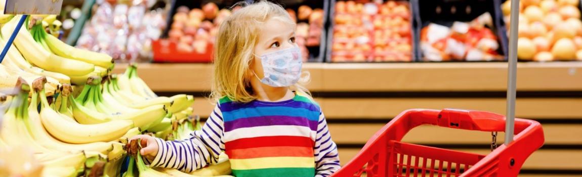 iStock.com/ romrodinka Mädchen vor Obstregal mit Kindereinkaufswagen