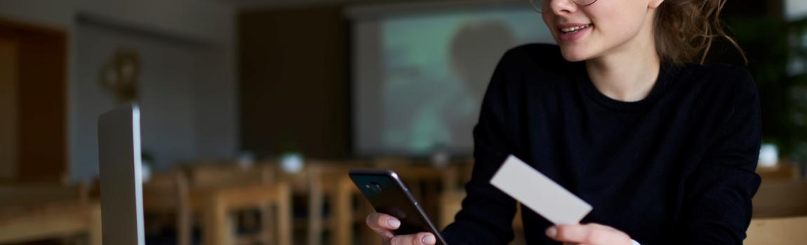 iStock.com/ GaudiLab junge Frau recherchiert mit Computer und Notizbuch