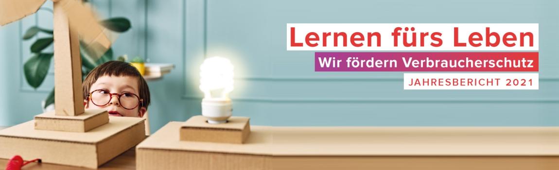 iStok.com/ pinstock kleiner Junge mit Brille beobachtet gespannt Windkraftanlage aus Papier und Glühbirne