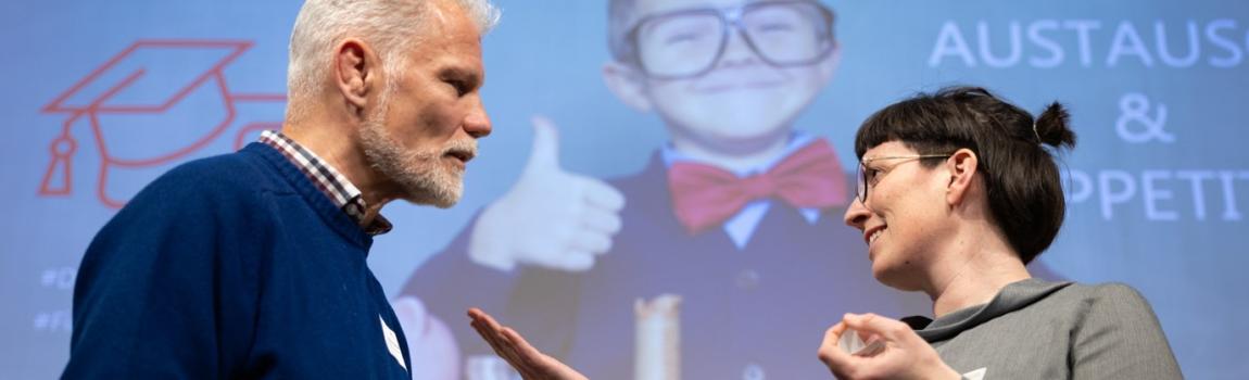 DSV/ Christian Mang zwei Menschen diskutieren vor Leinwand