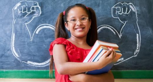 Mädchen vor Tafel mit Kreidemuskeln (c)iStock.com/diego_cervo